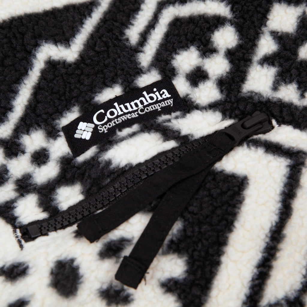 Black zipper with Columbia Sportswear Company logo on a patterned fabric background