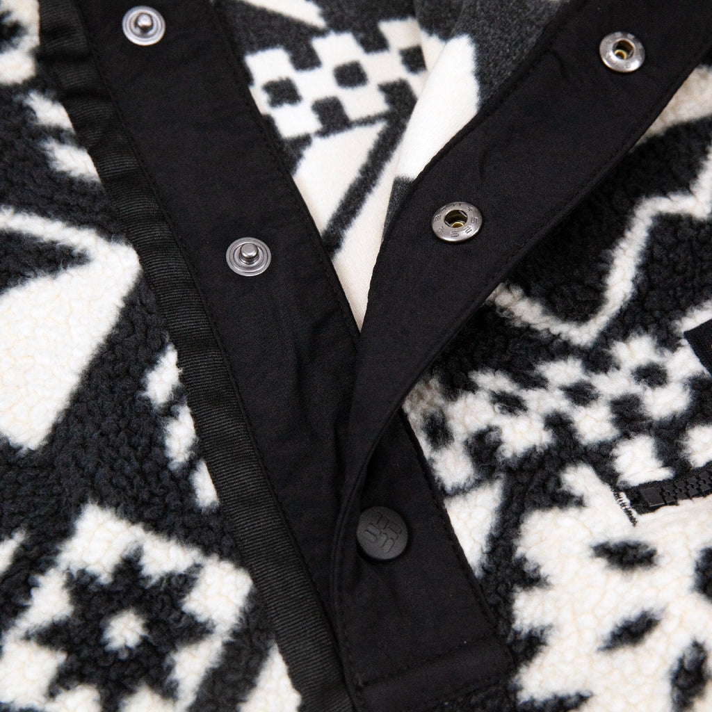 Close-up of a Helvetia Fleece II with buttons on a patterned fabric