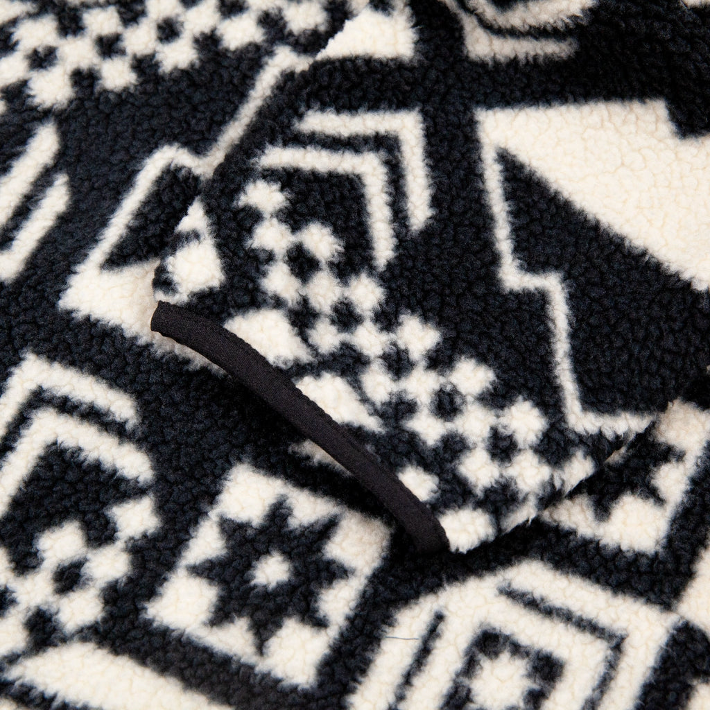 Close-up of a black and white patterned Columbia Helvetia Fleece II fabric with a black rubber cuff.